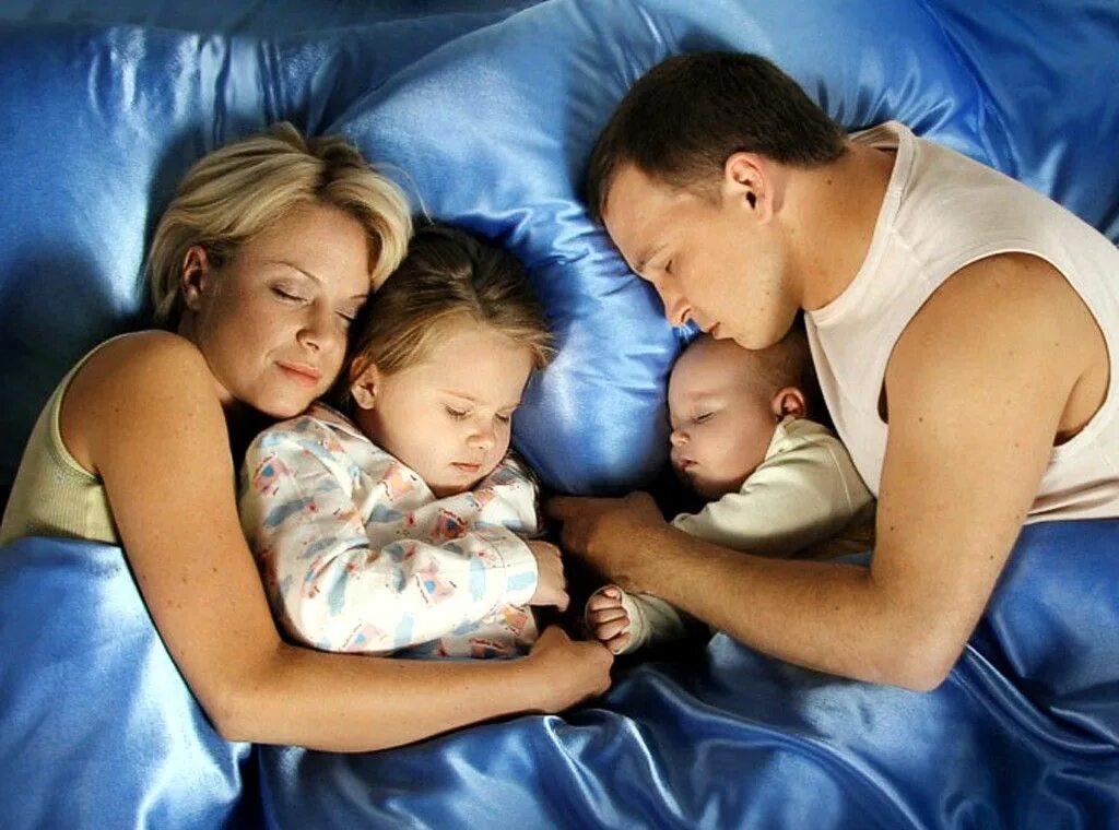 Однополая семья. Папа спит с малышом ночью. Семья нежность. Дети будят родителей. Мужчина и двое детей.