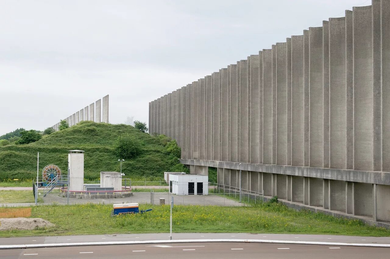 Стоит огромная стена. Ветровая стена Розенбурга. Rozenburg Нидерланды. Стена вокруг города. Огромная стена.