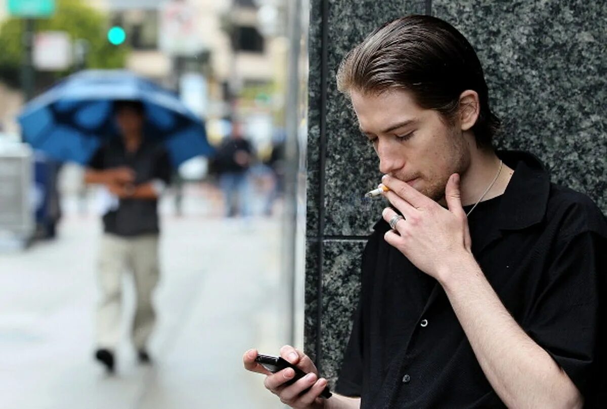 Курить можно мужчинам. Курящий парень на улице. Человек с сигаретой на улице. Парень курит на улице. Курящие мужчины на улице.