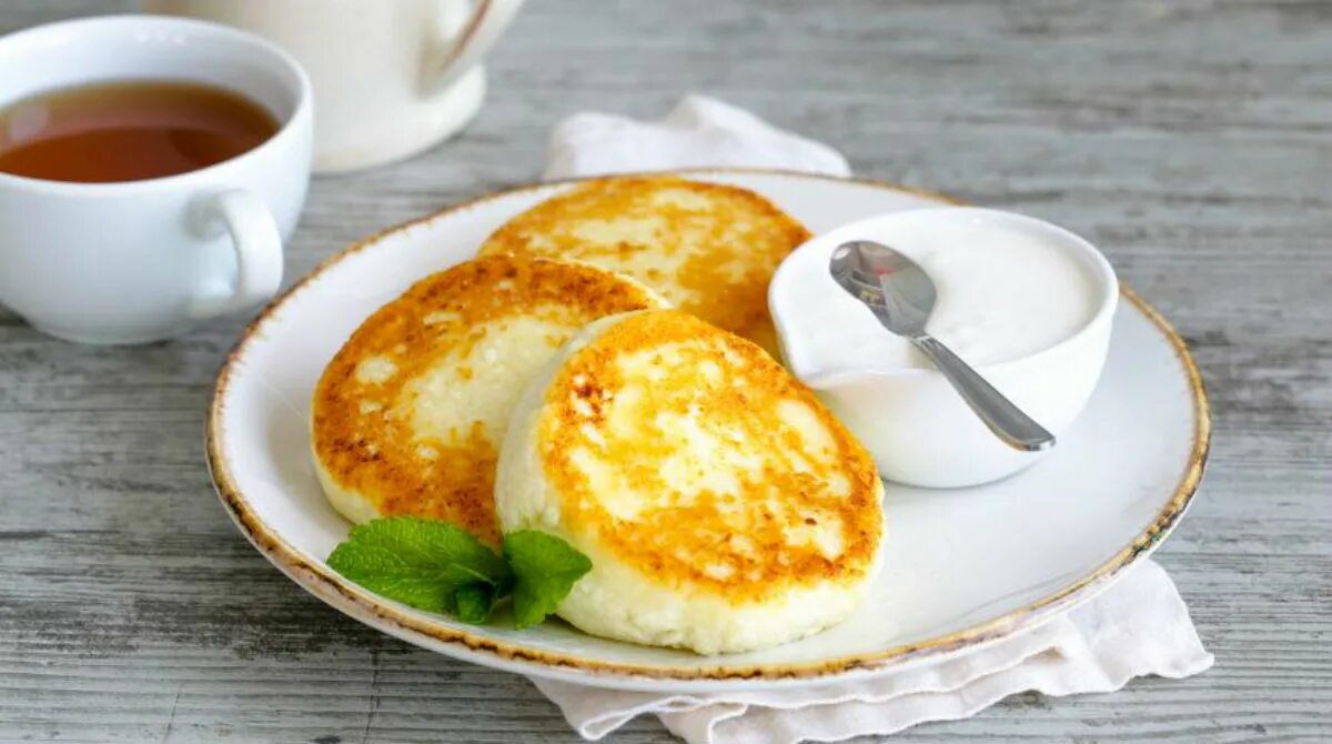 Завтрак из яиц и муки. Сырники. сырники со сметаной. сырники из творога со сметаной. блюда из яиц и творога.