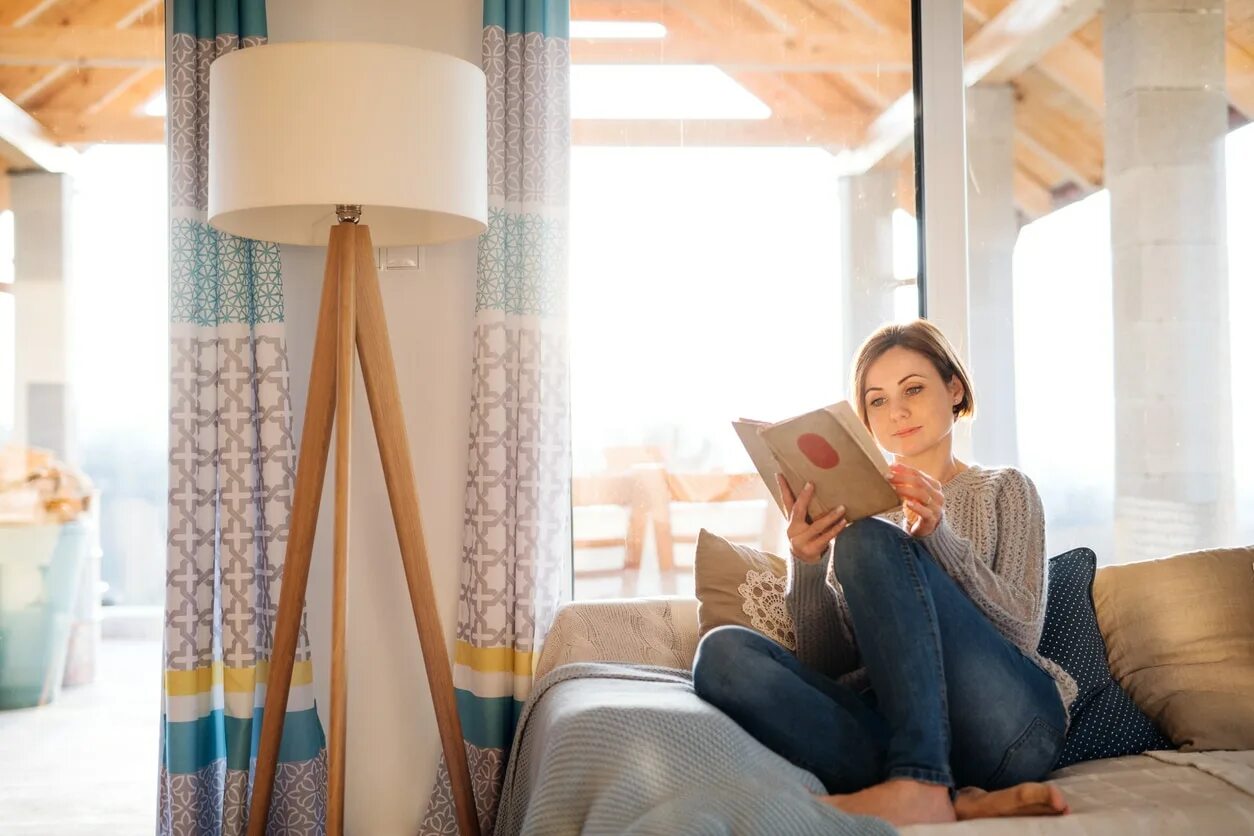 Девушка успешная свой дом. Девушка успешная домашний дом. Girl is reading book in the Living Room к. Read a book. To stay at home working