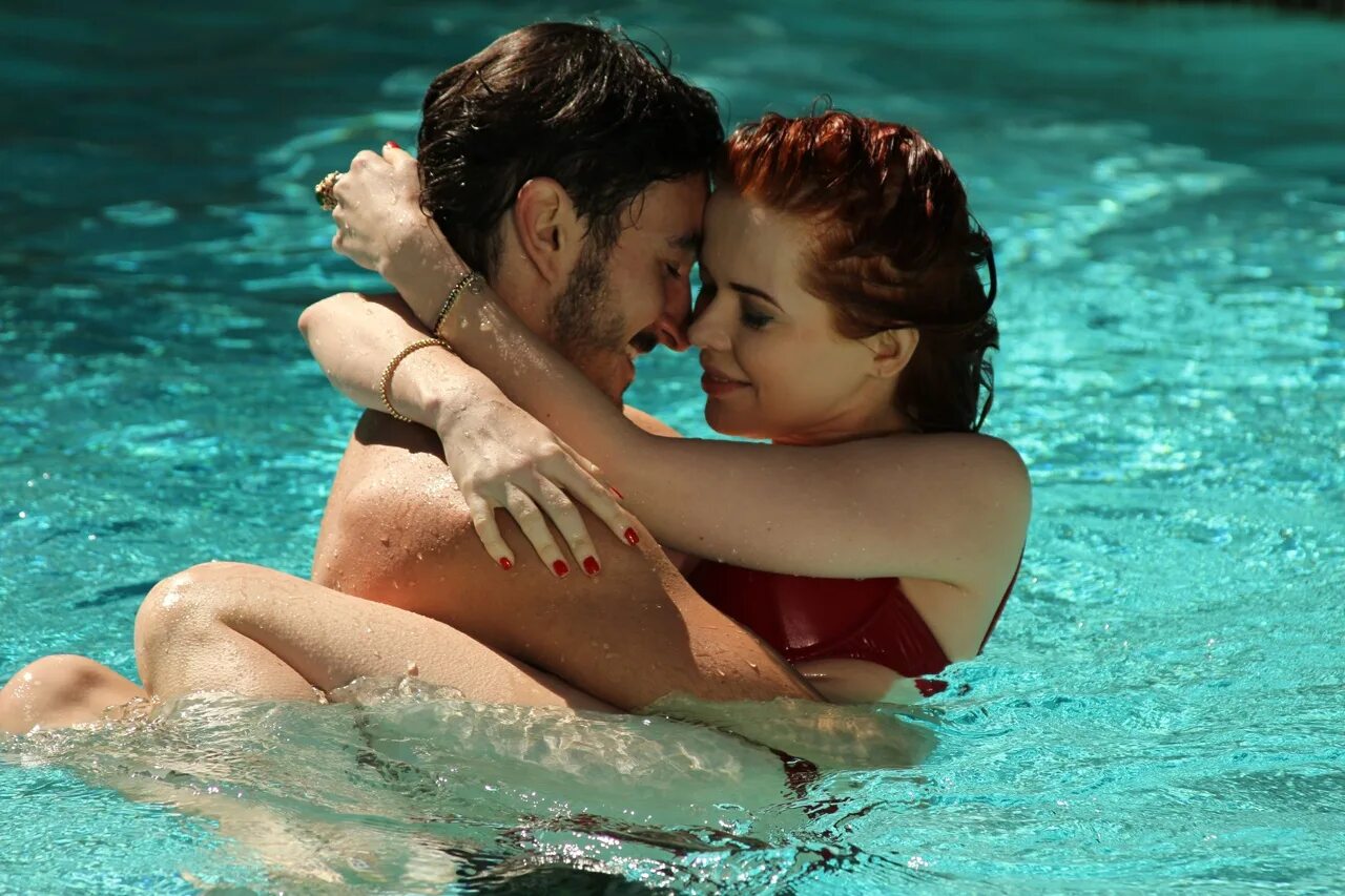 Девушка купается под водопадом. Блондин и брюнетка. Люди на пляже. Девочка и парень купаются. Парень.