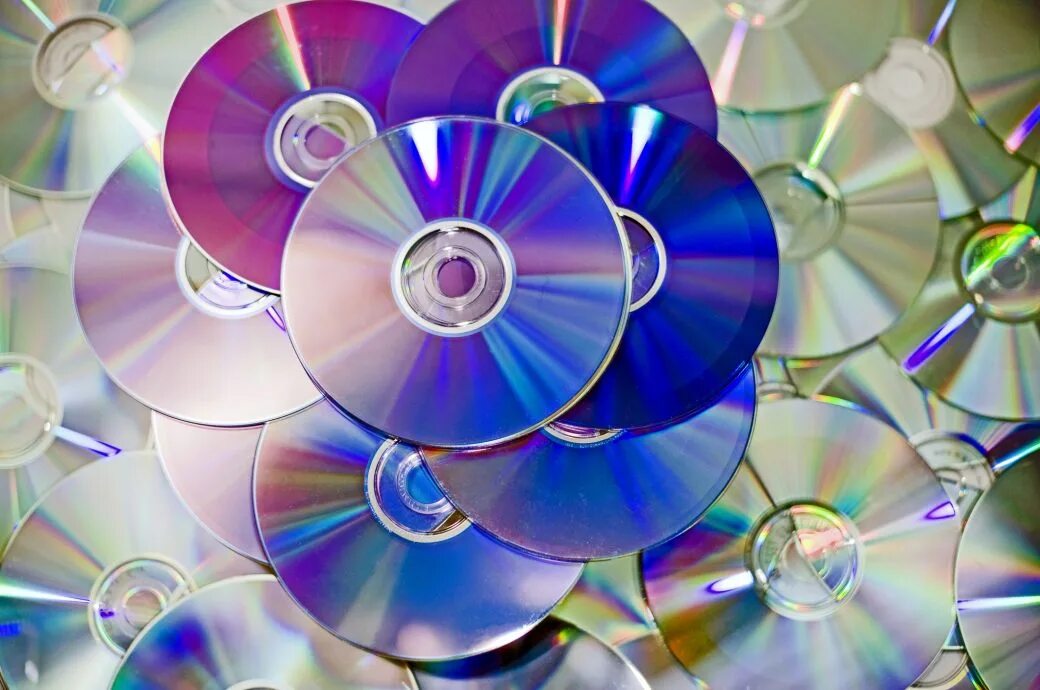 Компакт диски для стереосистемы. CD болванка цветная. Защита при помощи компакт-дис. Трещина на компакт диске.