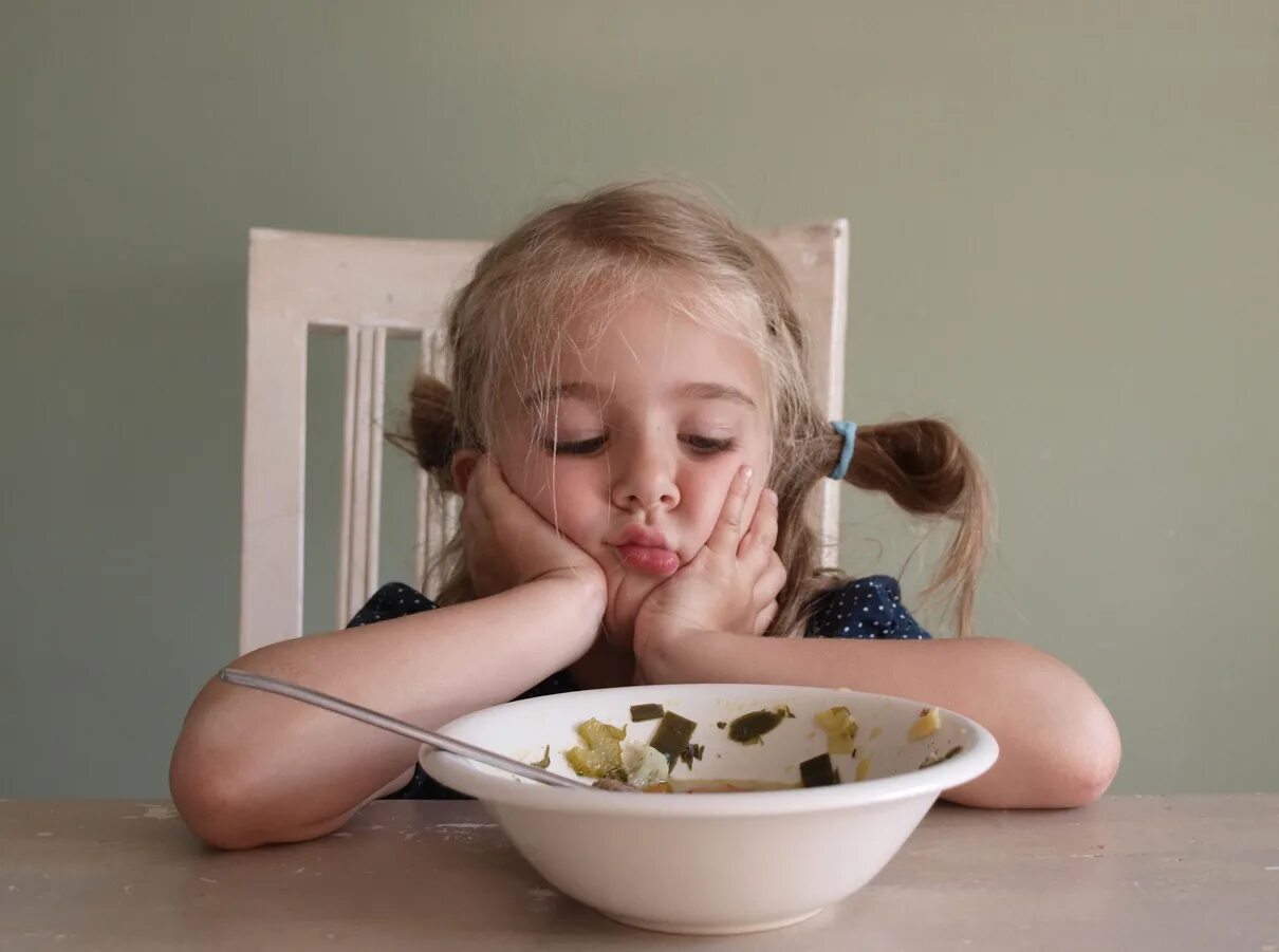 Невкусная еда. Ребенок ест суп. Ребенок не хочет кушать. Девочка кушает.