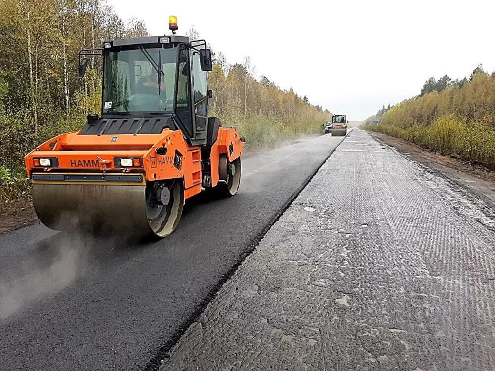 Укладка асфальта на трассе. Дорожно строительные работы. Дороги Архангельской области. Ремонт дороги.