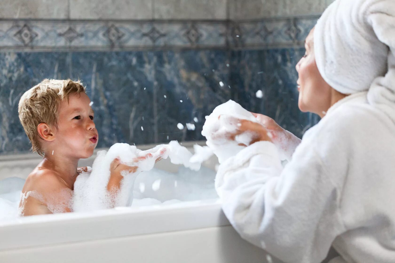 Молодой сын в душе. Ребенок в пене. Дети купаются в ванной. Мытье ванной. Малыши в пене в ванне.