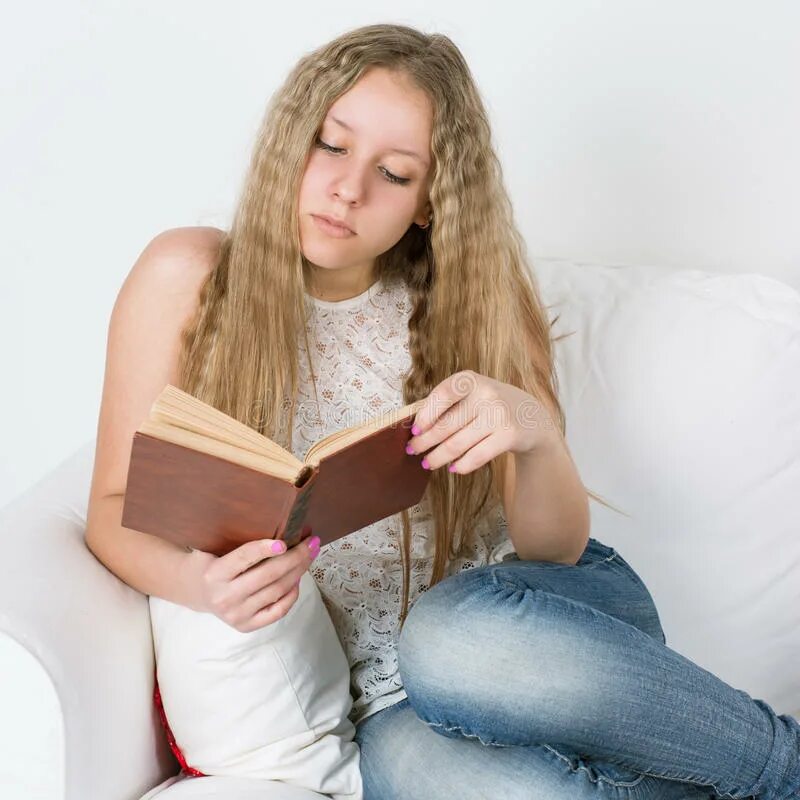 Девочка прочитала девочка 18. Девочка с книгой на диване. девушка сидит с книгой. девушка сидит читает книжку. девушка сидит на диване читает книгу.