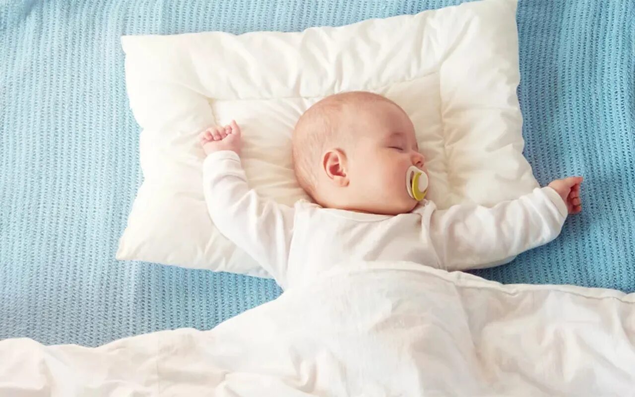 Какие подушки в год ребенку. Спящий ребенок. Малыш в кроватке. Младенец в кроватке.