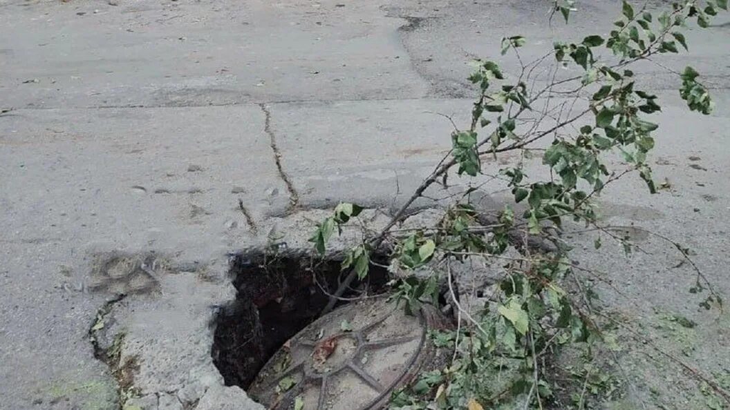 Ушел люк. Провалился в канализационный люк. Человек провалился под землю. Провал грунта у люка на дороге. Проваливается земля в городе.