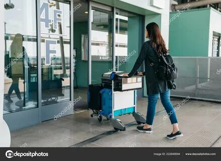 Young asian girl carrying luggage entering kansai international airport