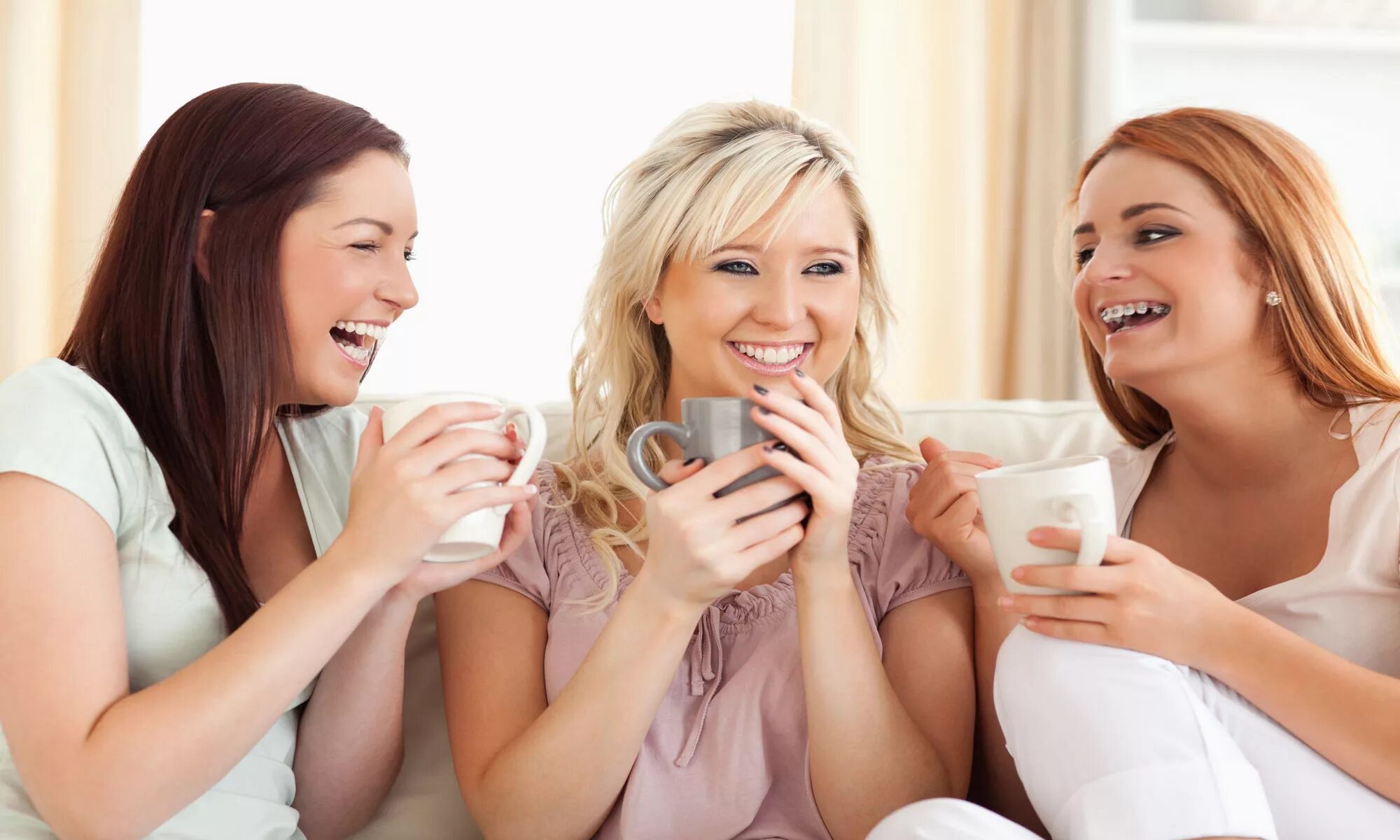 Расслабься подруга. Подруги смеются. Две девушки беседуют на диване. Подруги пьют чай. Девушка пьет чай и смеется.