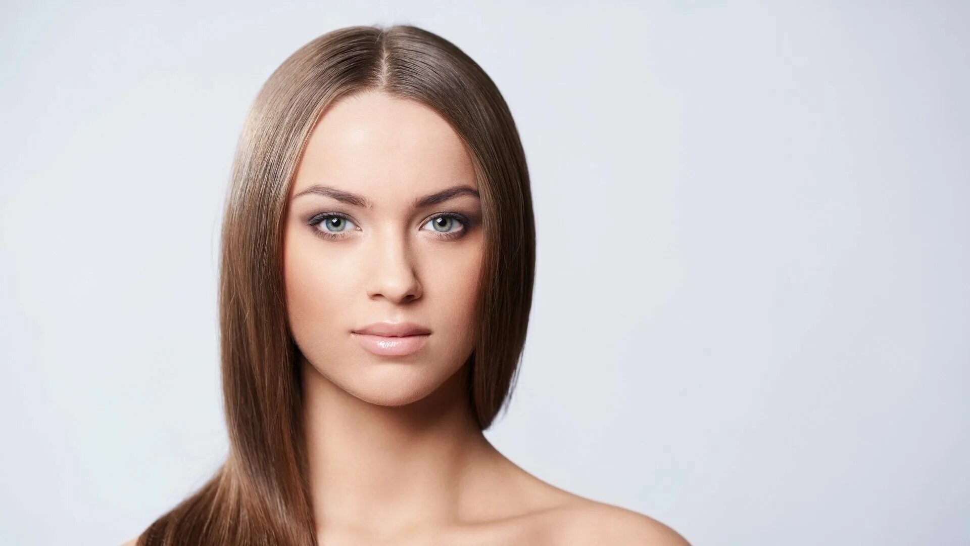 Лицо девушки. Брюнетка с веснушками и зелеными глазами. Лицо анфас. Девушка анфас. Лицо девушки.