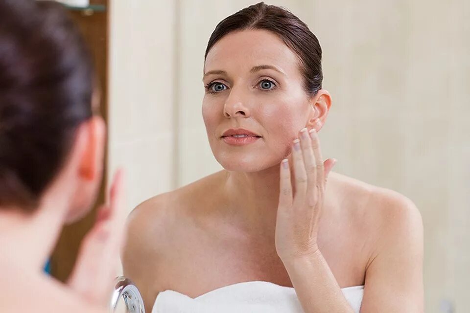 кожа в 50 как ухаживать. морщины на лице. взрослая женщина лицо омоложение. взрослая женщина наносит крем. женщина в возрасте наносит крем.