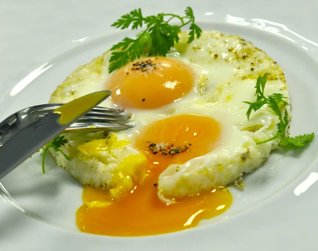 It шница. яйцо глазунья. яйцо куриное жареное. глазунья на белом фоне. жареные яйца.