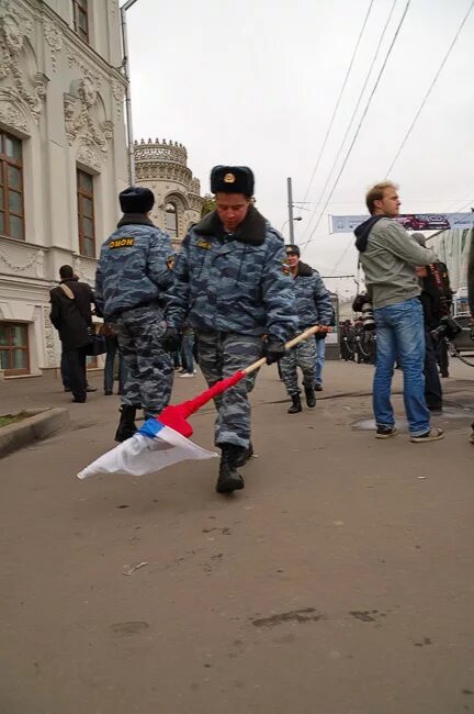 ОМОНОВЕЦ ломает российский флаг. Топчут российский флаг. Полицейский ломает российский флаг. 10 ноября 2008