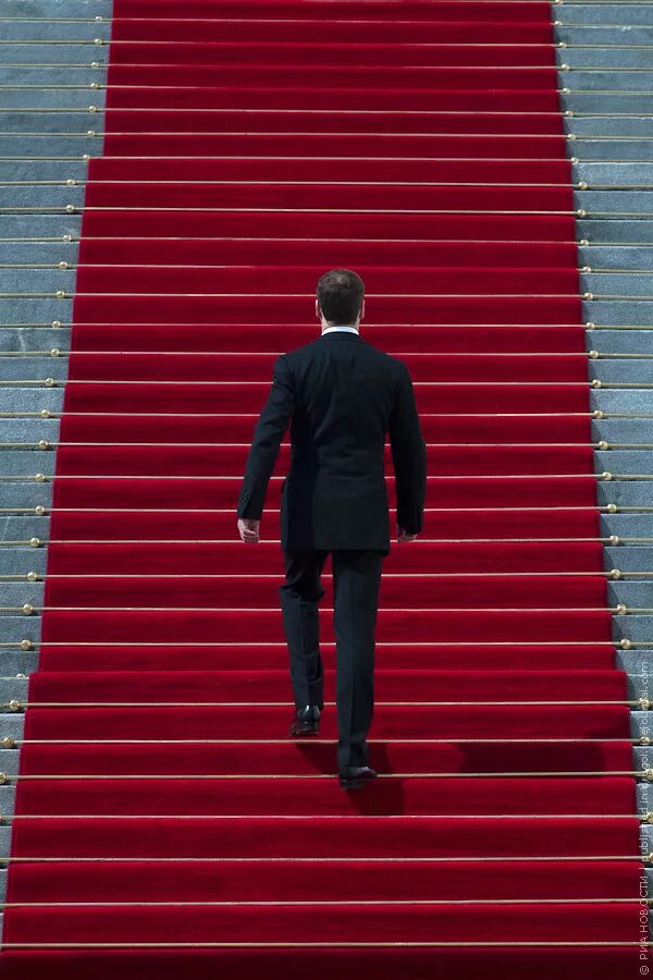 Мужчина поднимается по лестнице. Человек поднимается потлестнице. Человек поднимающий по лестнице. Человек на лестнице со спины. Челчевек идёт по лестнице.