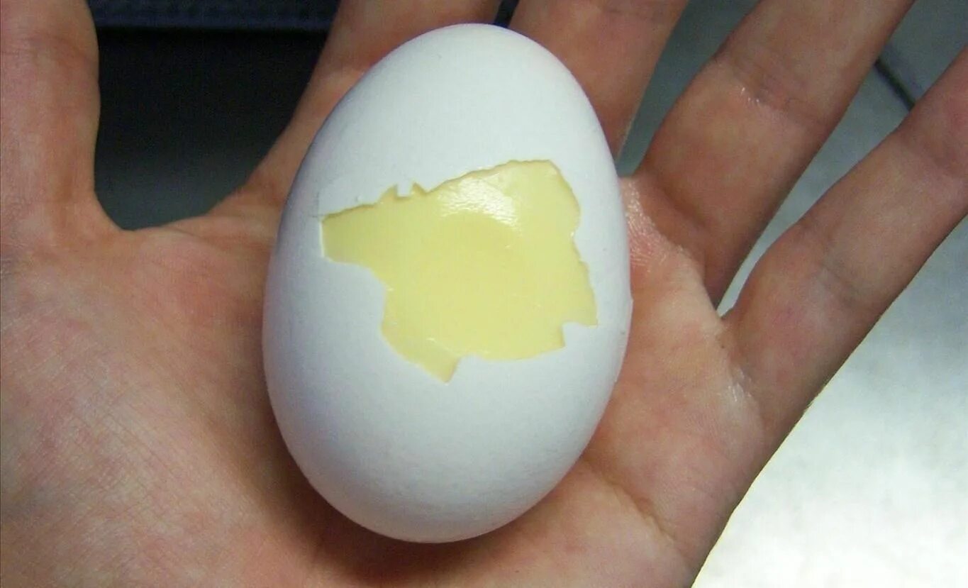 Золотое яйцо. Вареное золотое яйцо. Вареное яйцо в руке.