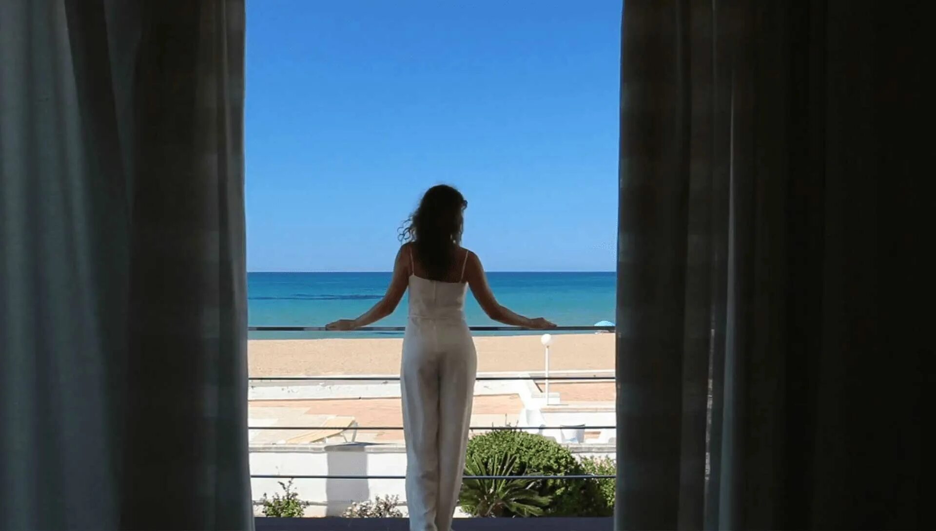 Девушка на балконе с видом на море. Девушка на балконе отеля. Женщина у окна с видом на море. Девушка на террасе с видом на море.