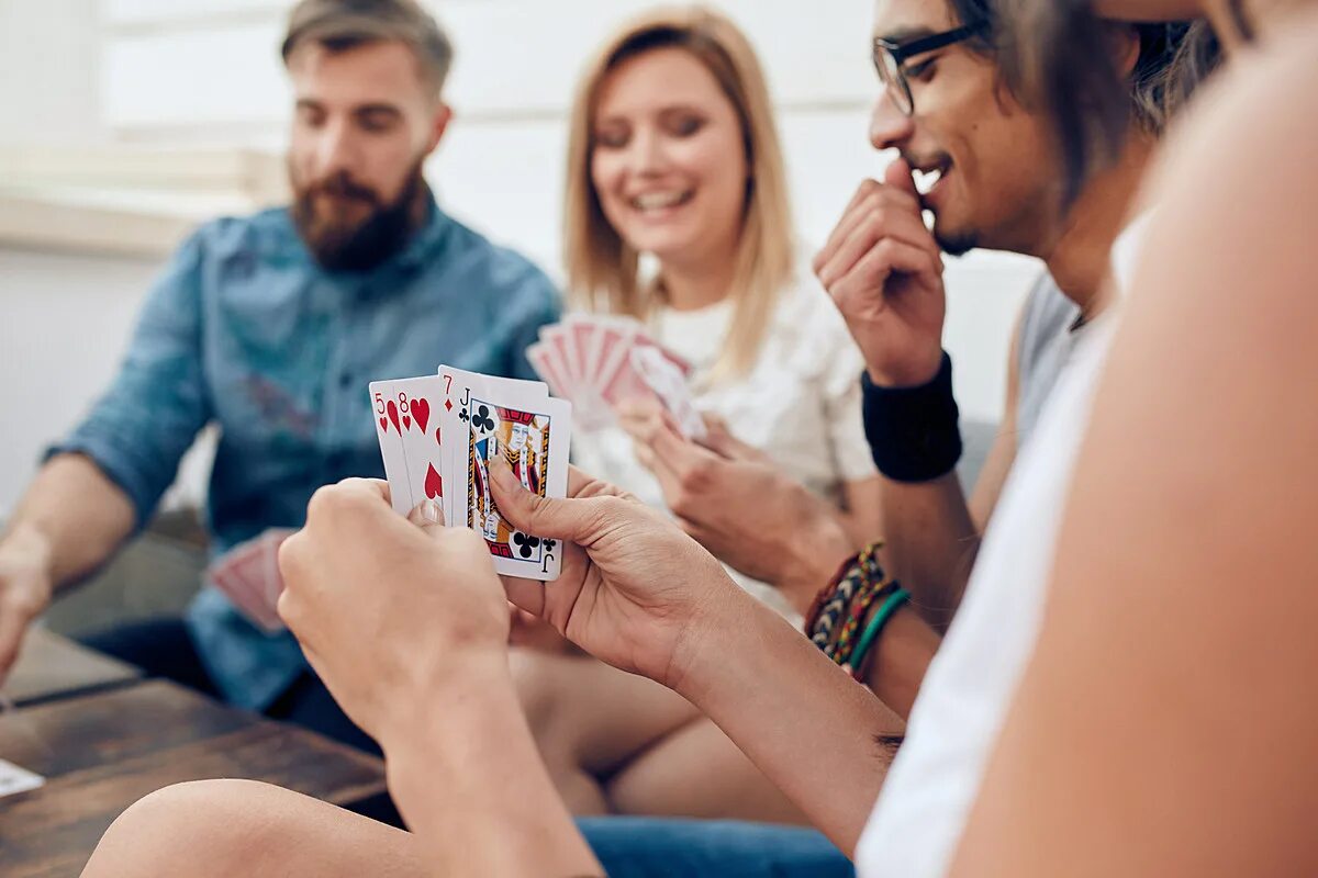 Друзья играют в карты. Люди играющие в карты. Игры для компании друзей. Весёлые люди играют в карты.