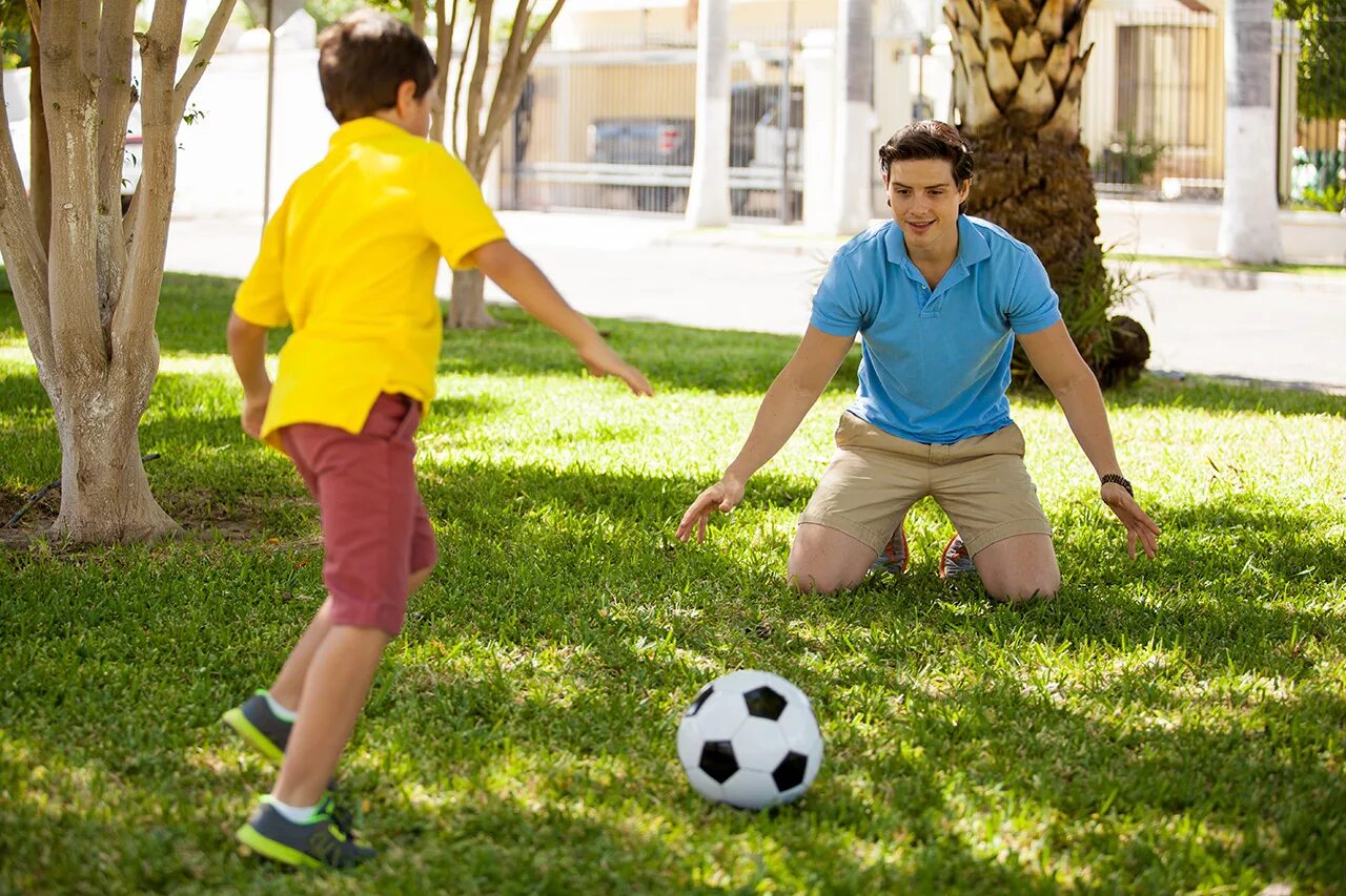 My brother plays football. Футбол с сыном. Семья с футбольным мячом. Мальчик играет в футбол. Паппа с детьми играет в мяч.