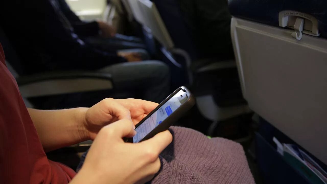 Телефон в воздухе. Отключать ли телефон в самолете. Рука женская возле окна самолета. Wi-fi в самолёте. Выключи телефон при взлете.