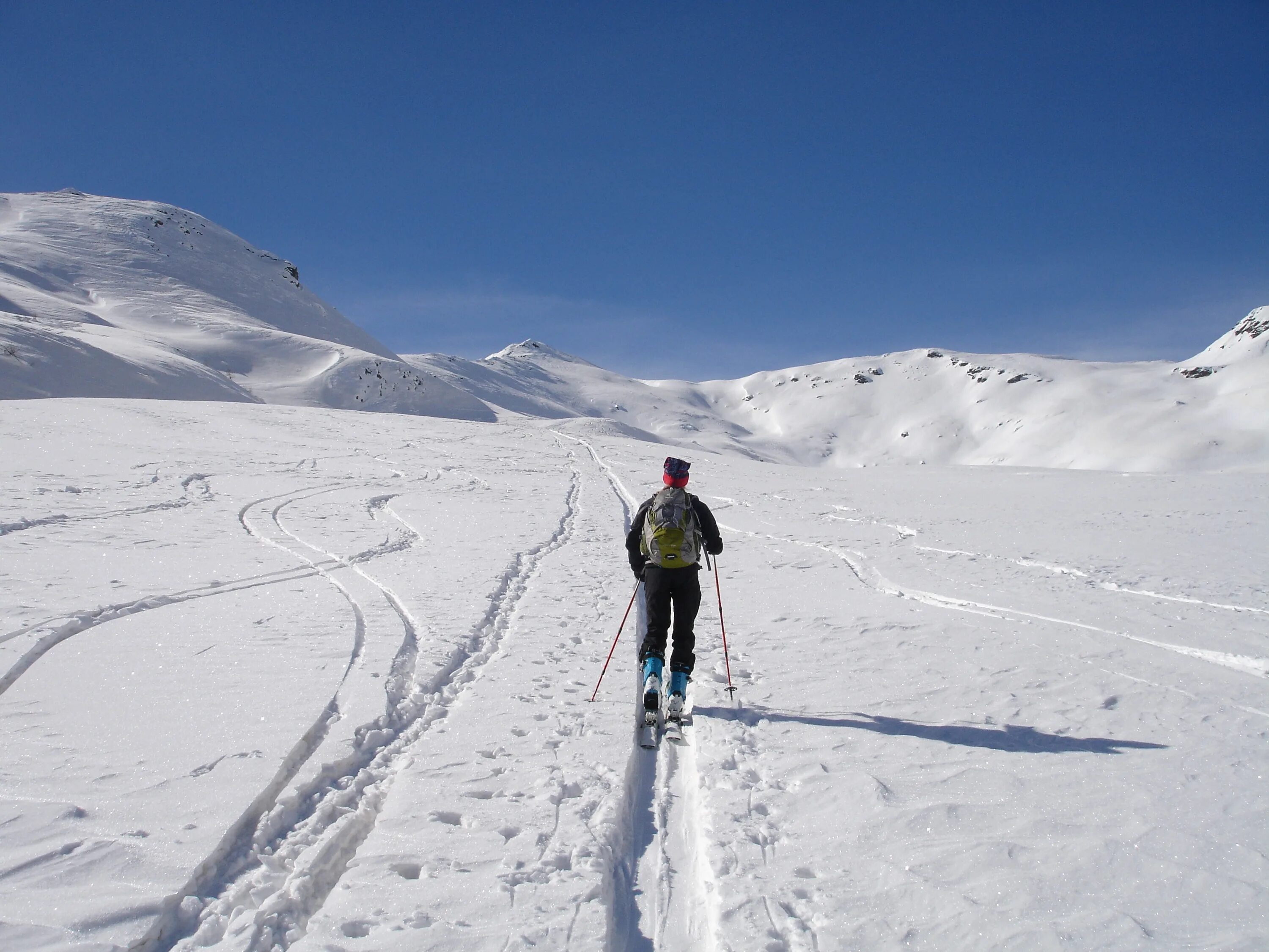 Skiing track. Лыжный туризм. Отдых в горах зимой. Бэккантри на горных лыжах. Лыжники на льду.