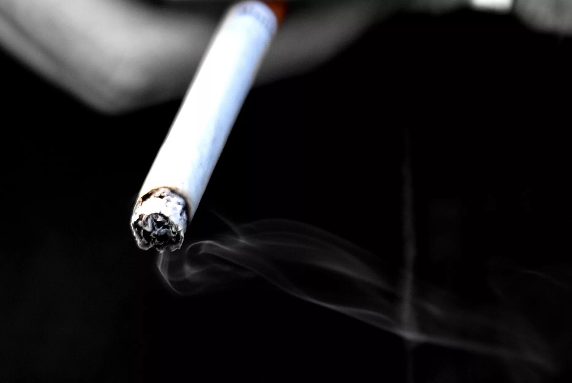 Вновь сигарета. Сигарета на черном фоне. Поджигает сигарету. Пепел сигареты. Тлеющая сигарета.