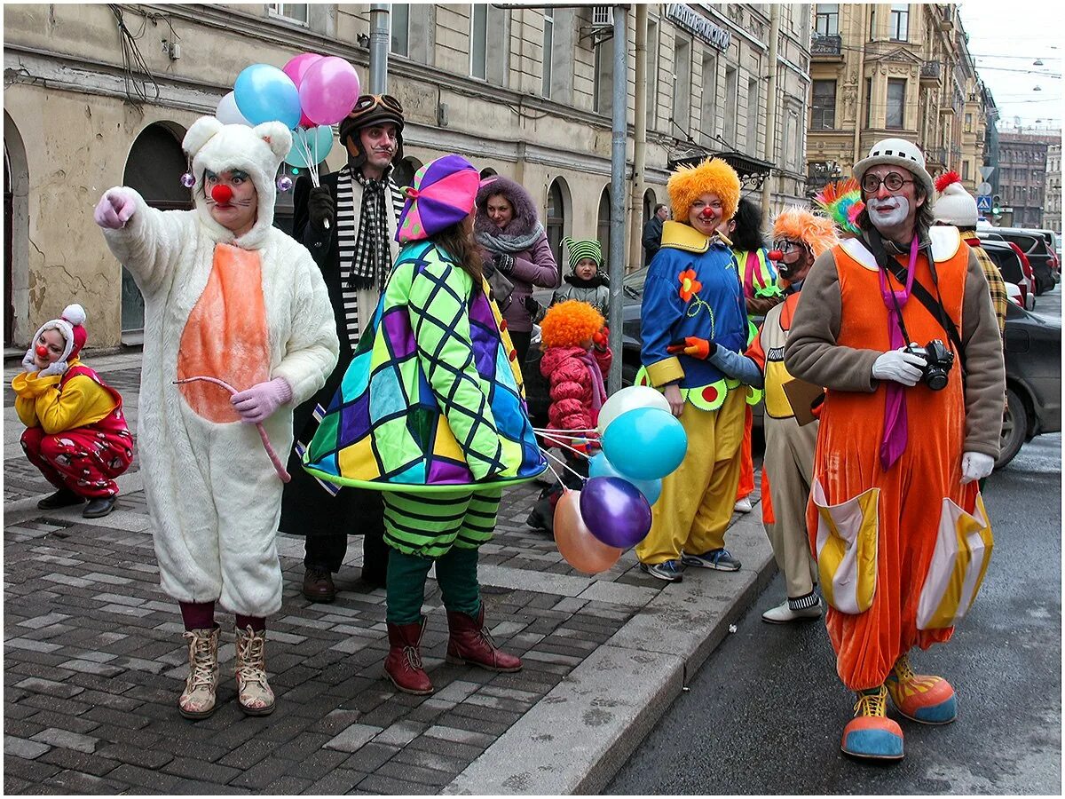 циркачи на ходулях. толпа клоунов. клоуны идут. парад клоунов. хоакин феникс джокер.