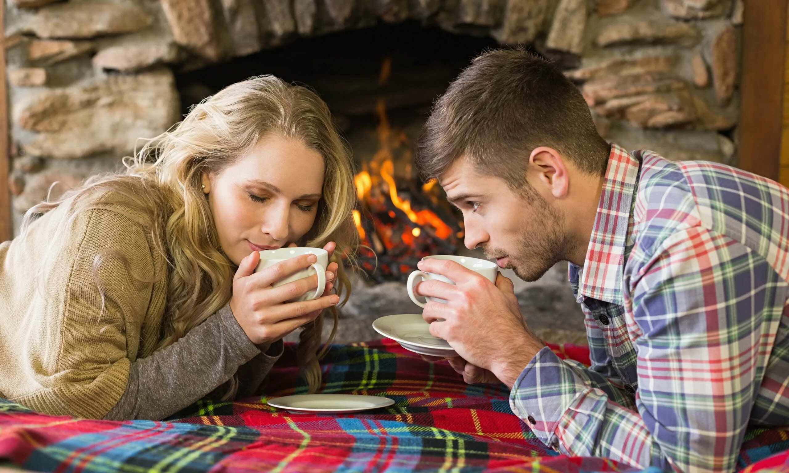 Natural couple. Уютный мужчина. Счастливая семья у камина. Влюбленные в доме. Мужчина и женщина пьют чай.