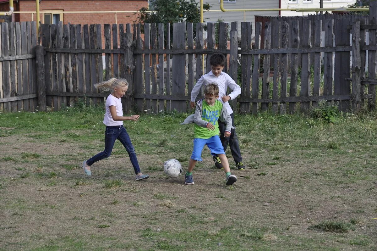Летом играем в футбол. Ребенок играется во дворе. Футбол во дворе. Детский футбол во дворе. Дети играющие во дворе.