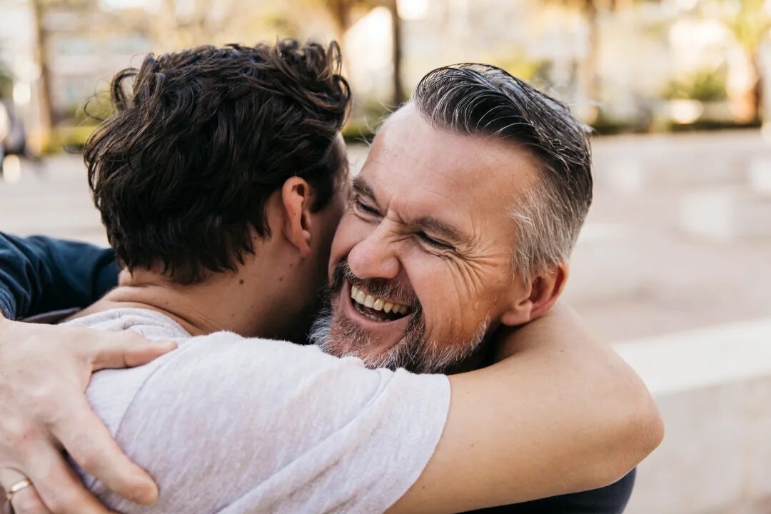 разговор с подростком. молодой и пожилой человек. счастливый брак. мужчина и женщина в возрасте. отец и сын обнимаются.