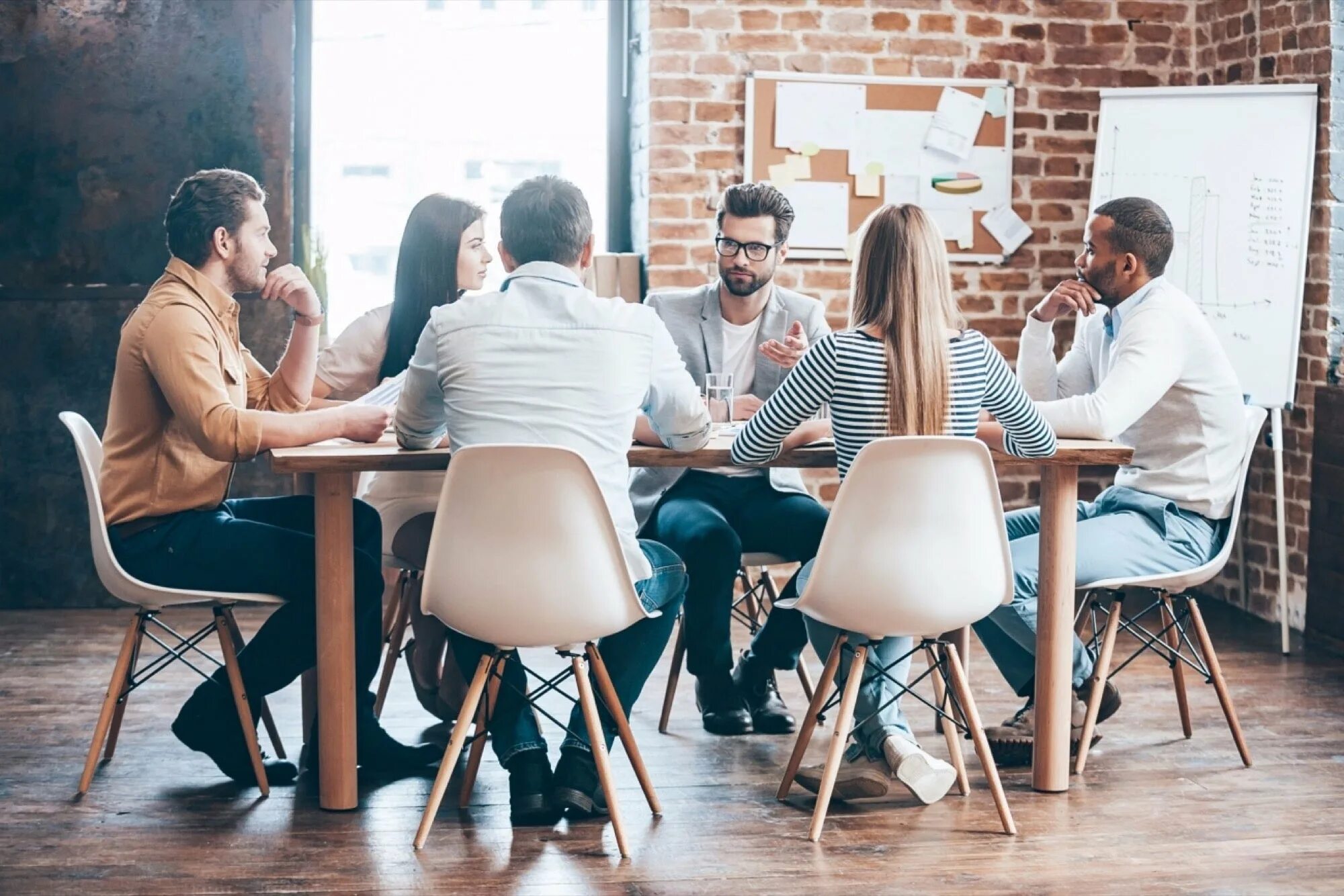 The student is the table. Креативный коллектив. Группа людей за столом. Человек сидит за столом. Люди за столом в офисе.