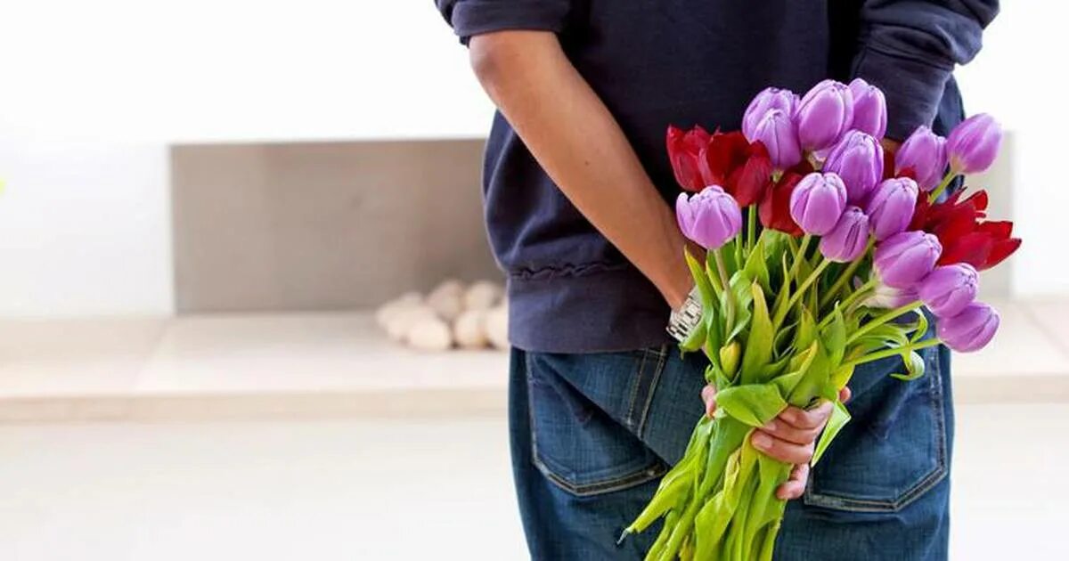 Мужчина дарит цветы женщине. Какие цветы дарят на 8 жене