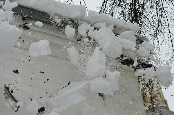 падающий сугроб. сход снега с крыши. снег упал на машину. снег на крыше машины. сход снега с крыши.