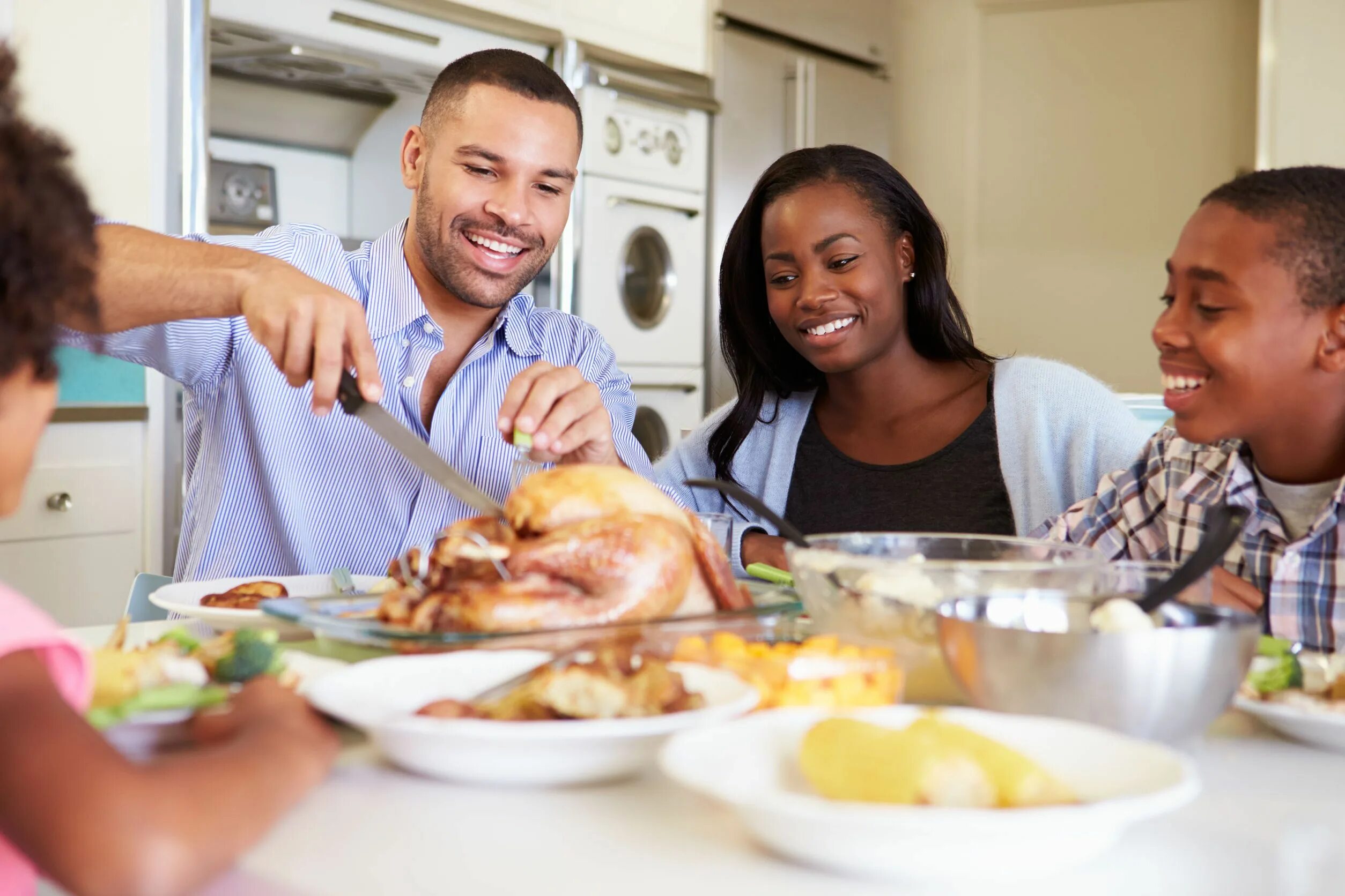 Is that eat in or. Культ еды в семье. eating out vs eating at home. big black family eating stock photo. people around the table.