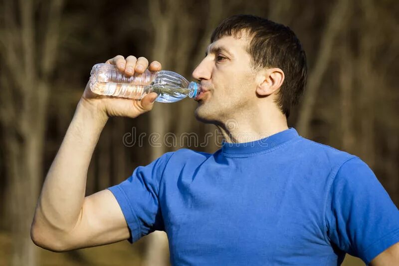 Человек пьет из бутылки. Мужчина пьет из бутылки. Парень пьет воду из бутылки. Мужик пьёт много воды.
