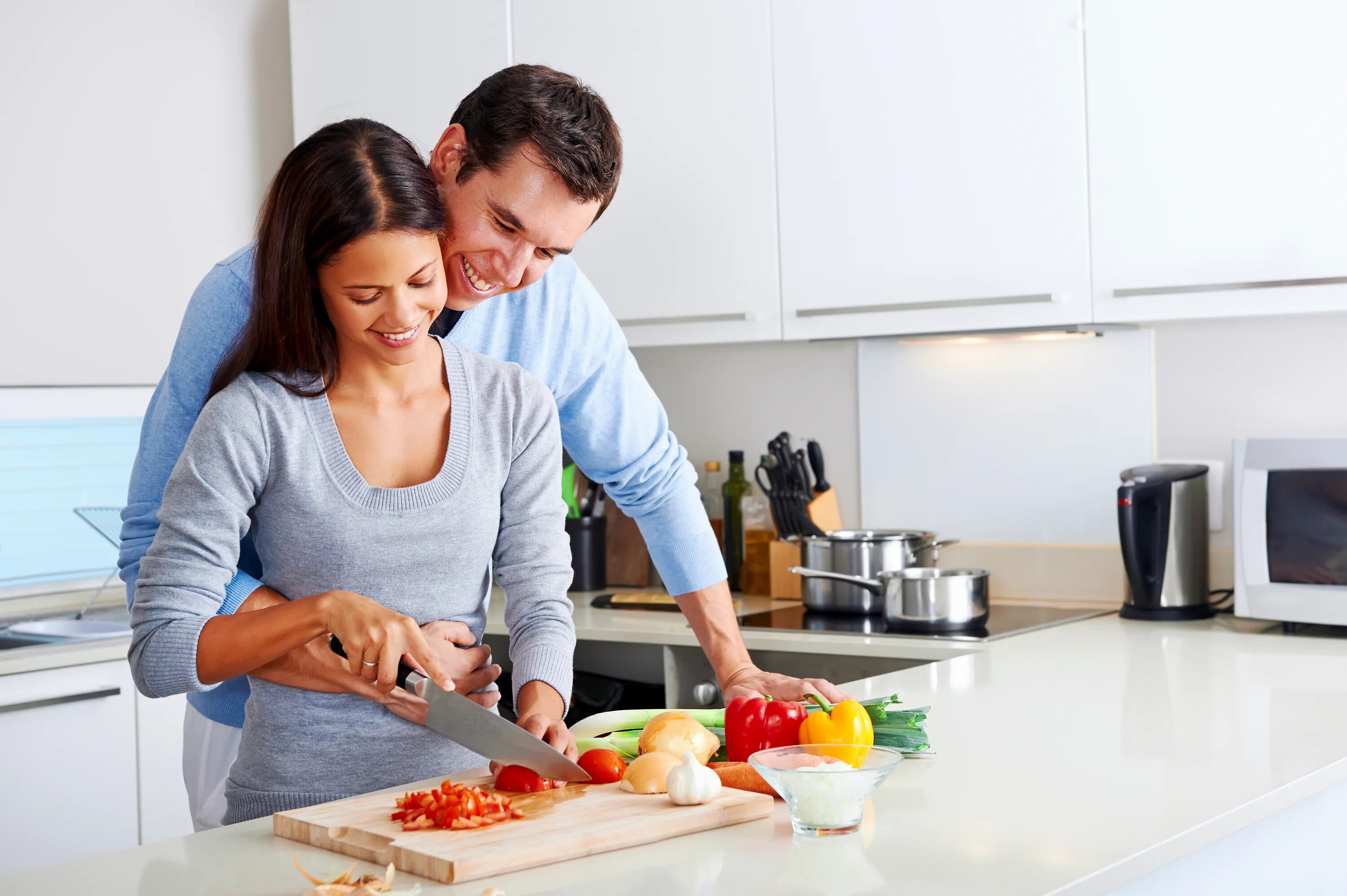 Муж и жена делают друг другу. Счастливая семья на кухне. Готовим вместе. Готовка на кухне. Пара на кухне.