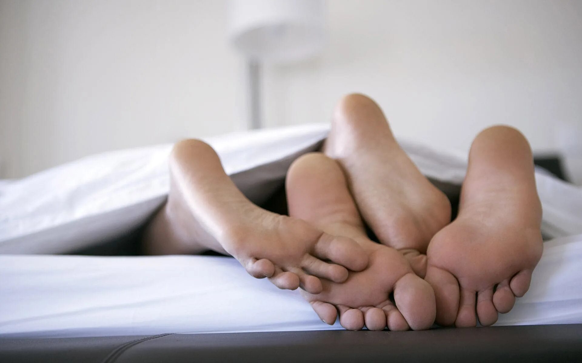 Что такое миссионерская. Мужские и женские ступни. Ноги на кровати. Пятки под одеялом. Мужские и женские ноги в кровати.