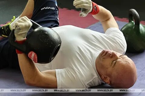 Спортсмен поднимает гирю массой 12 кг