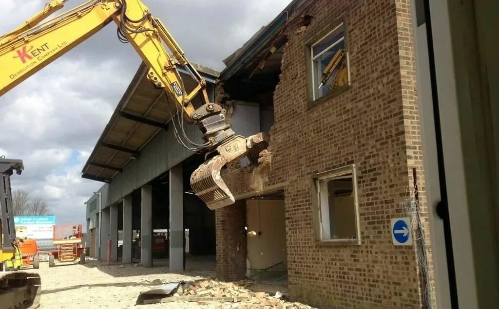 Экскаватор для разрушения зданий. Демонтаж кирпичного здания. Снос кирпичных зданий экскаватором демонтаж строй. Снос кирпичных зданий экскаватором демонтаж строй. Сносят дом.