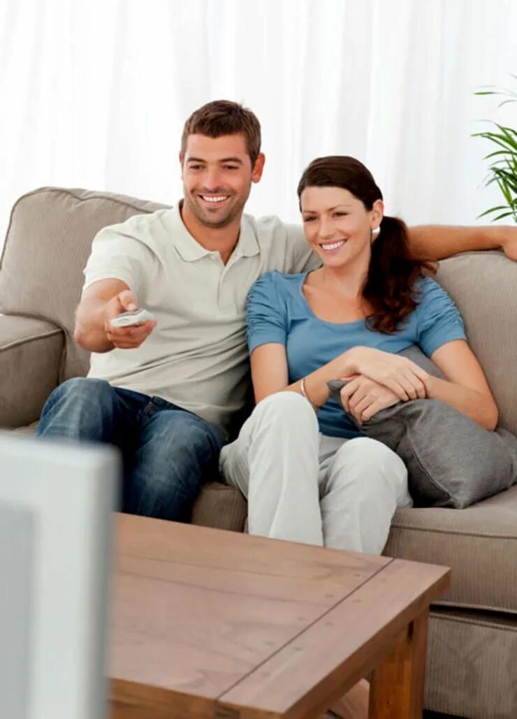 Мужчина и женщина смотрят телевизор. Счастливые люди в 1к квартире. Фон семья у телевизора. Husband watching.