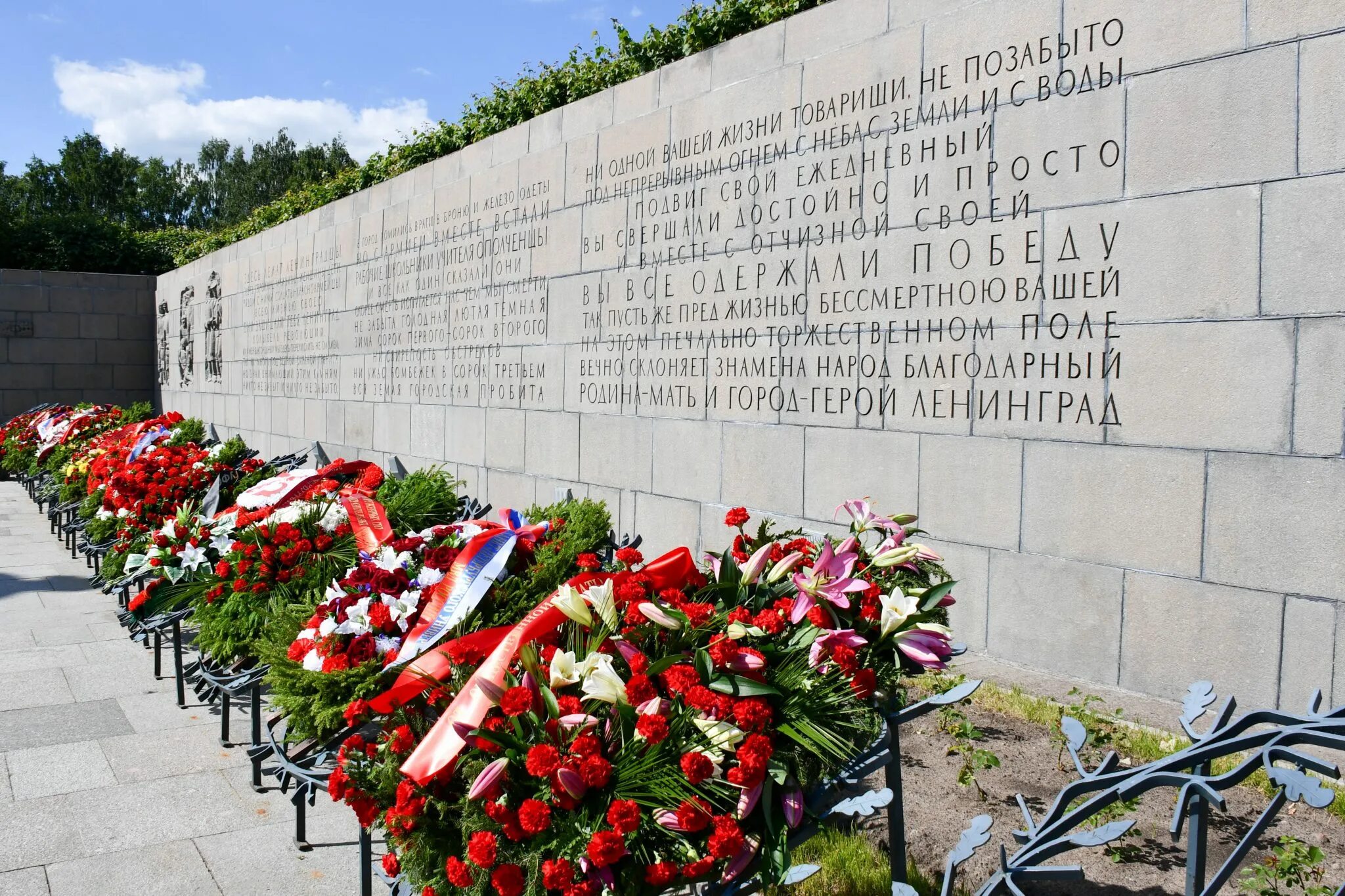 Похороненных на пискаревском. Пискаревский мемориал. Пискаревское мемориальное кладбище, г. Санкт-Петербург. Мемориальная стена Пискаревского кладбища в Санкт Петербурге. Памятники блокады Ленинграда Пискарёвское кладбище.