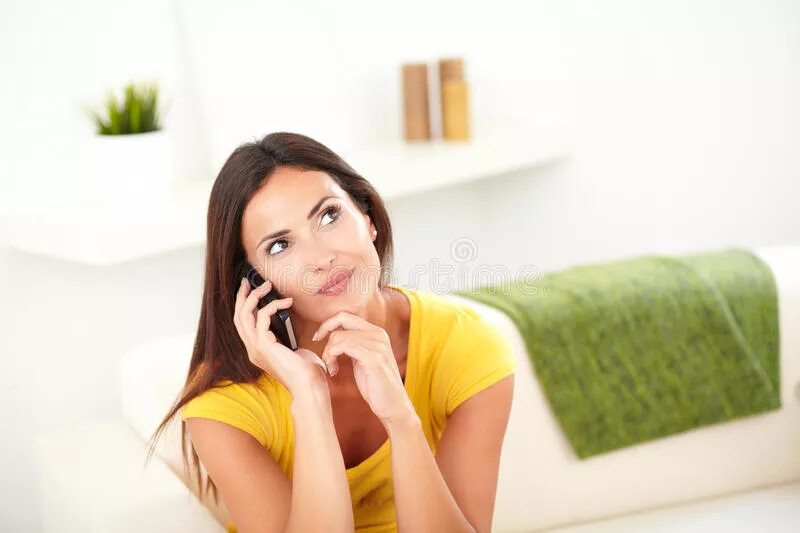 Девушка с телефоном задумалась. Поправляет прическу. Девушка трогает волосы при разговоре. Накручивает волосы на палец. Alexandra yun модель.