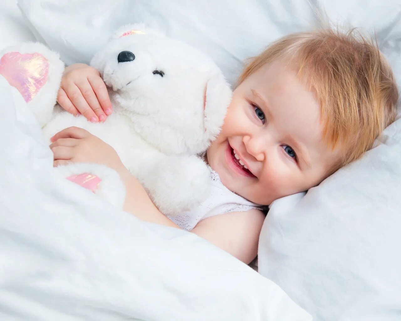 Кровать для детей. Малыш под одеялом. Плюшевый мишка врач милый.