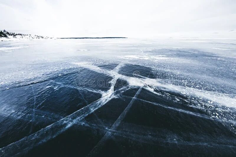Замерзшее озеро в трещинах. Черный лед на озере. Трещины на поверхности голубого льда. Снег и лед трещины.