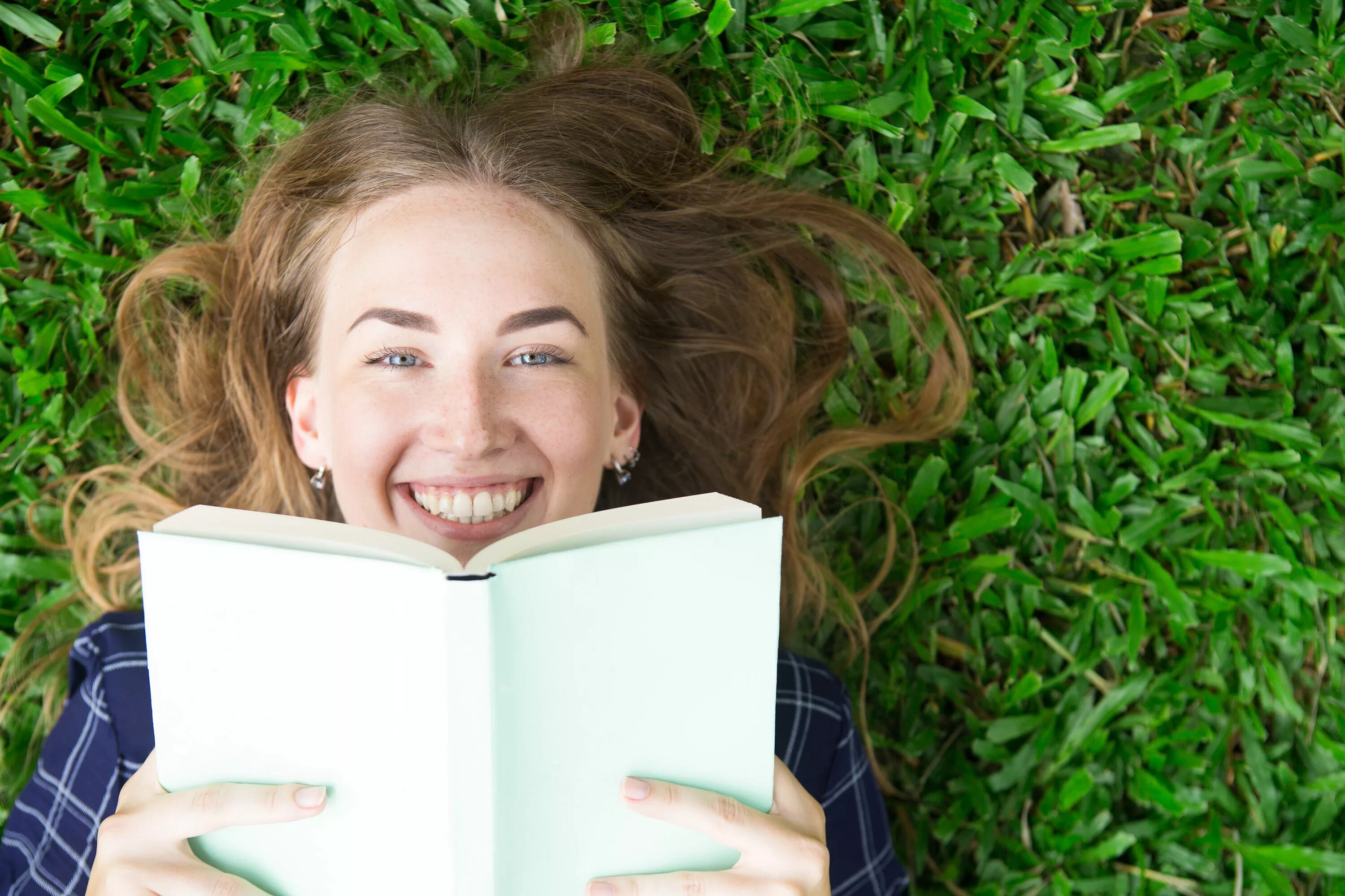 Девушка с книгой улыбается. Девочка с книжкой на траве. Девушка на траве с книгой. Девушка бумажная книга лайк.