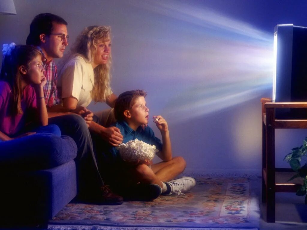 Семья у телевизора. Человек телевизор. Человек смотрит телевизор.