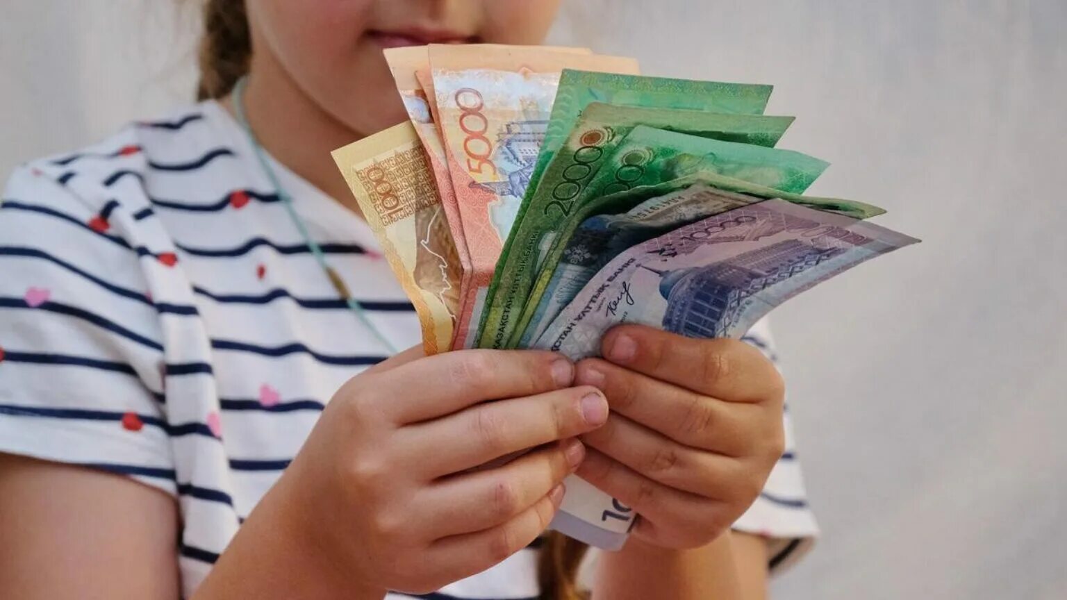 Деньги в руках. Соцвыплаты в Казахстане. Дети и деньги. Выросли социальные пособия.