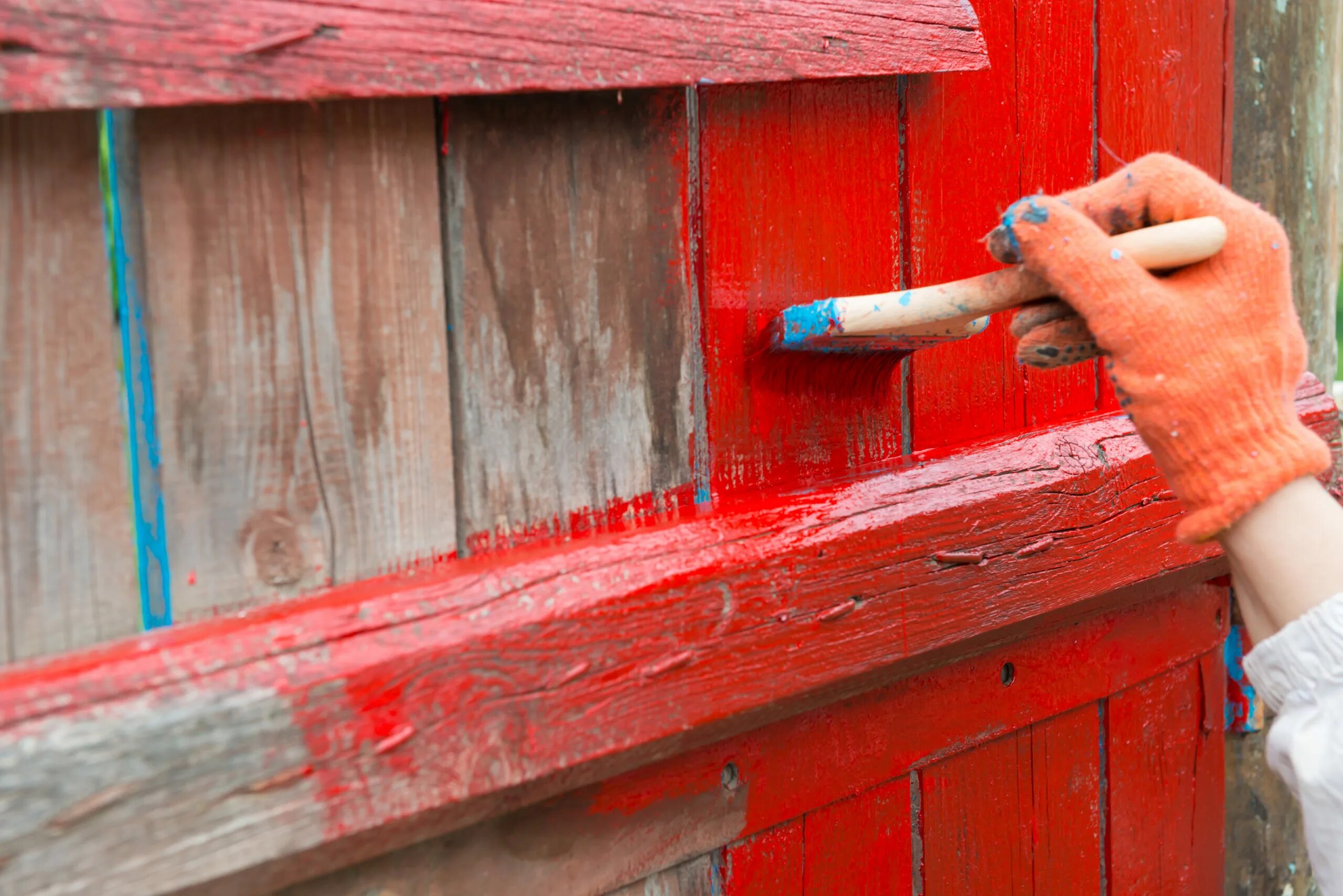 Чем покрасить деревянный забор на улице. Покрасить забор. Крашенное дерево красный. Красить забор красной краской. Красный цвет краска для деревянных заборов.