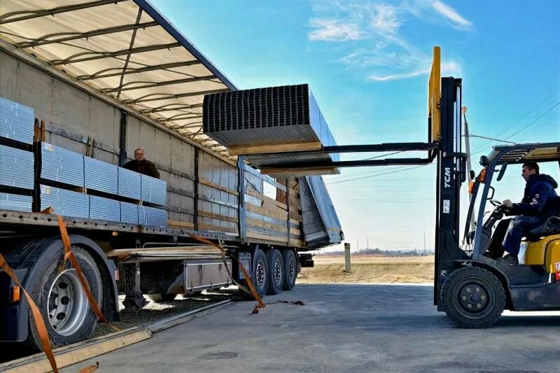 Разгрузка фуры погрузчиком. Разгрузка товара на складе. Машина с гидролифтом. Автомобиль для грузоперевозок. Машина для перевоза ящиков.